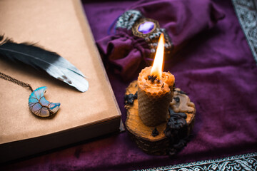 Illustration for esoteric contents, scene with a candle and book of spells , esoteric concept, fortune telling, other magic stuff on a table	
