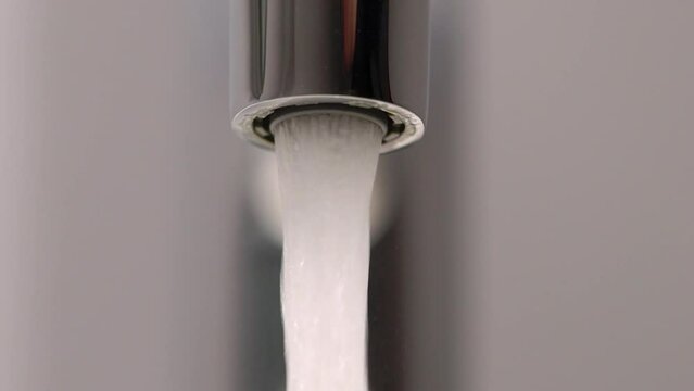 Opens the mixer valve. A jet of water runs from a water pipe.