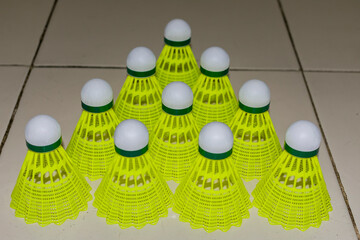 Nylon made yellow color badminton shuttlecock close view looking awesome placed on floor in different position. - 483740911