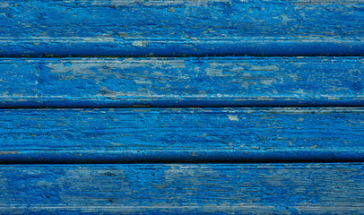 Vintage wood background. Old weathered wooden plank painted in blue color. Boards with cracked and peeling paint. Old painted wood wall - texture or background.