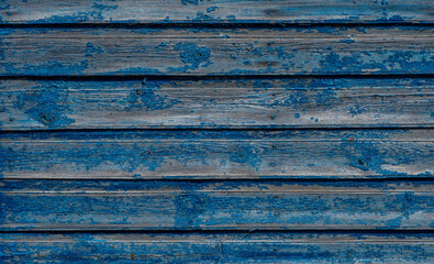 Vintage wood background. Old weathered wooden plank painted in blue color. Boards with cracked and peeling paint. Old painted wood wall - texture or background.