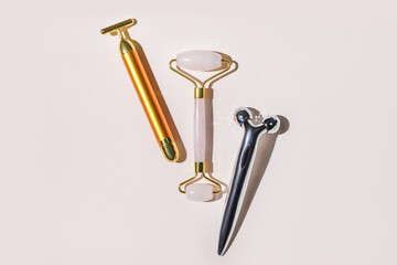Different face massage rollers on light background