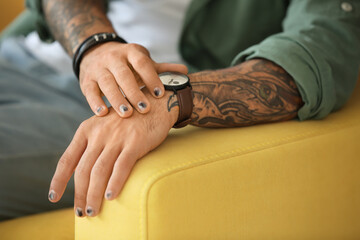 Fototapeta premium Male hands with stylish manicure on sofa armrest, closeup