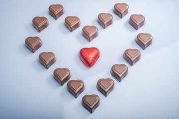 Closeup of heart shaped chocolate confections against a bright white background.