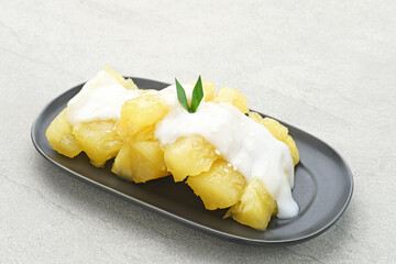 Singkong thailand, sweet cassava, made of boiled cassava, sugar and coconut milk. Served in bowl and pandan leaf, selective focus.
