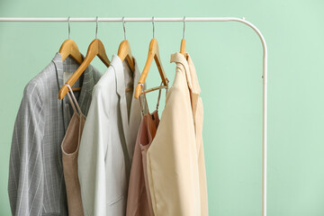 Obraz premium Rack with clean female clothes on green background, closeup
