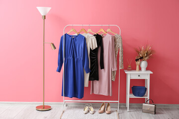Interior of room with hanger, floor lamp and table near color wall