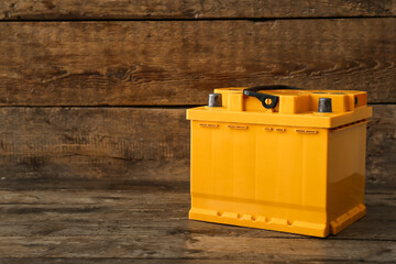Modern car battery on wooden background