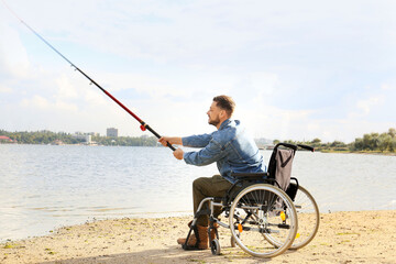 Man in wheelchair fishing on river