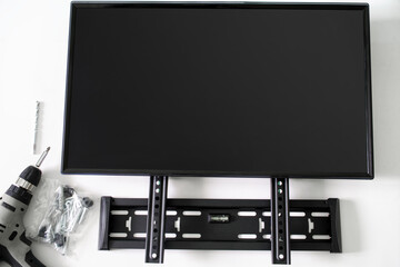 \Bracket for wall mounting a TV or computer monitor, an electric drill driver, screws and a monitor...