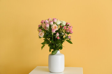 Vase with bouquet of beautiful roses on table