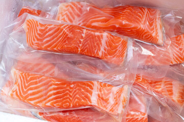 Fresh salmon fillet in vacuum package for delicious salmon menu. - obrazy, fototapety, plakaty