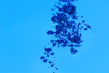 Obraz premium Clear water with air bubbles on blue background