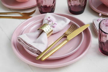 Stylish table setting and flowers on light wooden background