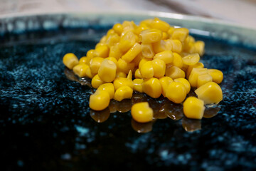 corn on a beautiful glazed plate on the wooden table