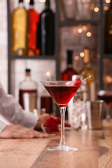 Glass of tasty Manhattan cocktail on wooden table