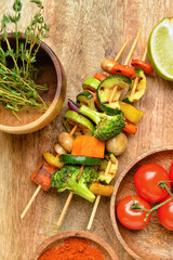 Tasty vegetable skewers on wooden background