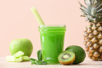 Glass of healthy green juice and fresh fruits on table