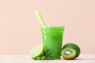 Glass of healthy green juice and fresh fruits on table