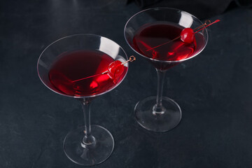 Glasses of tasty Manhattan cocktail on black background