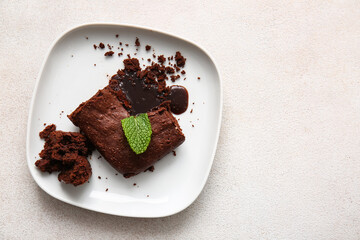 Plate with pieces of tasty chocolate brownie on white background