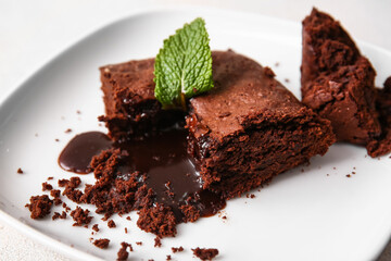 Plate with pieces of tasty chocolate brownie on table, closeup