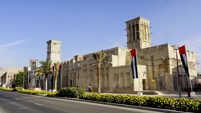 United Arab Emirates National Flag Waving In The Wind With Traditional Buildings In The Background In Al Fahidi In Dubai, UAE. - wide shot