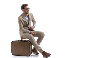 sexy businessman sitting on a chair, next to his briefcase