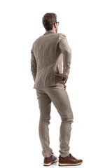 handsome businessman standing with one hand on his hip