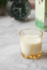 Close up of glass of milk and spoon on table 