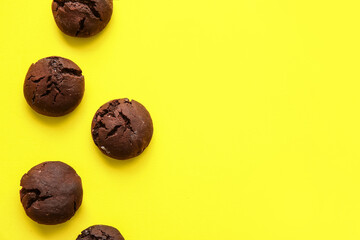 Tasty chocolate brownie cookies on yellow background
