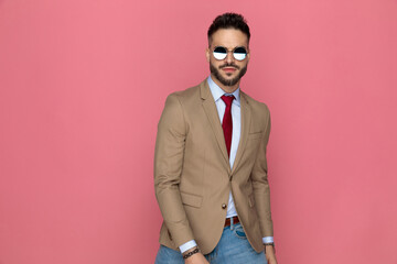 young man posing against pink background with attitude