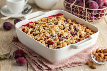 Plum streusel cake in white baking dish