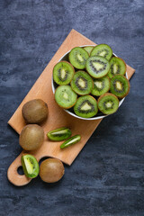 Bowl with fresh cut kiwi on dark background