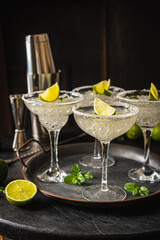 Margarita cocktail with lime and ice on dark wooden table with copy space. Classic Margarita and Daiquiri Cocktail.