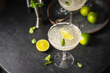 Margarita cocktail with lime and ice on dark wooden table with copy space. Classic Margarita and...