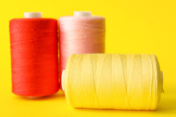 Multicolored sewing thread spools on color background