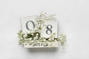 Calendar with date of International Women's Day and flowers on white background