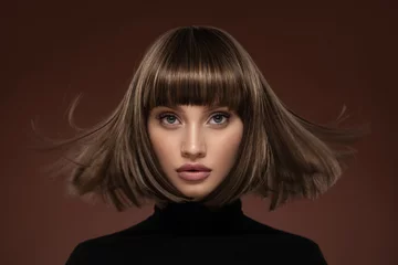  Portrait of a beautiful brown-haired woman with a short haircut on a brown background © yuriyzhuravov