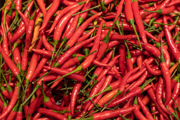 Close up Organic fresh red chillies texture in basket on shelf in supermarket.Spicy and hot of red chilis peppers in grocery store.Fresh organic chili concept