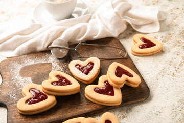 Fototapeta na wymiar Board with tasty cookies for Valentine's Day celebration on light background