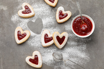 Tasty cookies and jam for Valentine's Day celebration on grey background