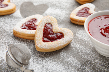 Tasty cookies and jam for Valentine's Day celebration on grey background, closeup