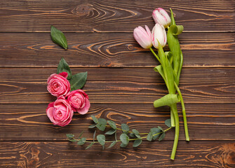 Composition with beautiful flowers and eucalyptus branch on wooden background