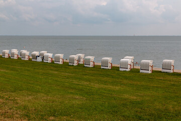Obraz premium Beach chairs stand in a row on the North Sea