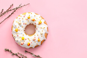 Plate with tasty Easter cake and pussy willow branches on pink background