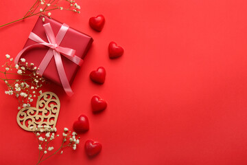 Composition with tasty heart-shaped candies and flowers for Valentine's Day celebration on red background