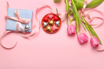 Composition with tasty heart-shaped candies and flowers for Valentine's Day celebration on pink background