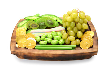 Wooden board with different sweets and grape for St. Patrick's Day celebration on white background