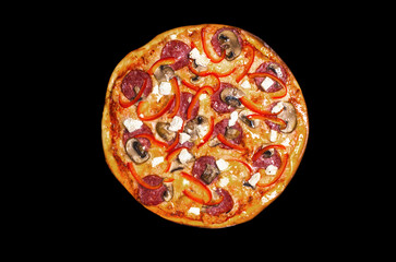 Pizza, a traditional Italian snack. Lots of ingredients, cheese, tomatoes, bell peppers, sauce, salami, champignon mushrooms, feta cheese. Top view, round, not cut. Isolated on black background.